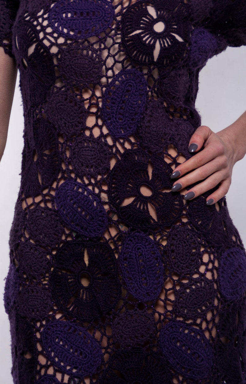 May include: A purple crochet dress with a floral pattern. The dress is made of a lightweight, breathable fabric and has a loose, flowy fit.