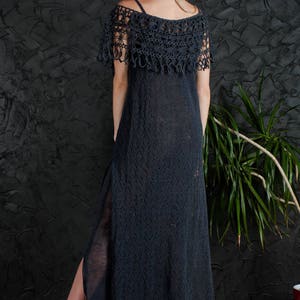 May include: A long, black crochet dress with a lace overlay and a side slit. The dress is made of a lightweight, breathable fabric and has a relaxed fit.