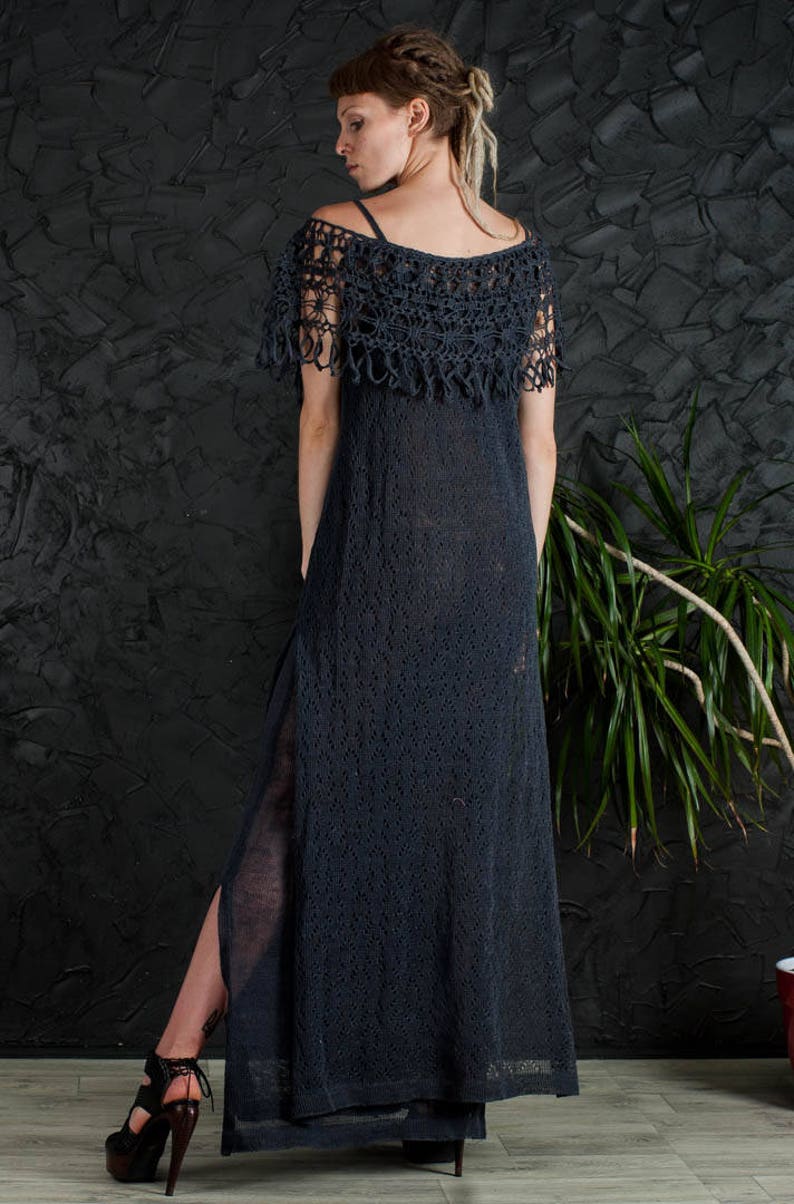 May include: A long, black crochet dress with a lace overlay and a side slit. The dress is made of a lightweight, breathable fabric and has a relaxed fit.