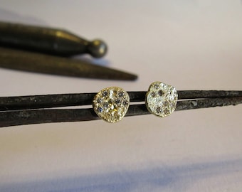 Puede incluir: Un par de pendientes de oro con pequeñas piedras preciosas transparentes engastadas en una forma irregular texturizada.