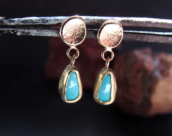 May include: A pair of gold earrings with turquoise stones. The earrings have a round top and a teardrop-shaped bottom.