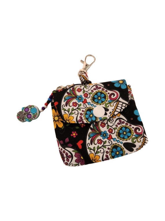 Sugar skull mini coin purse,air pod earbud holder, lipbalm hand sanitizer holder. Attach to purse or lanyard. Sugar skull lovers delight