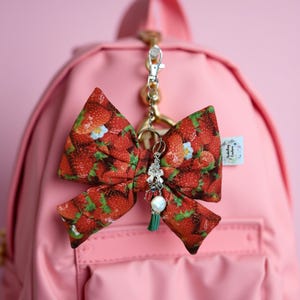 Puffy Bow Keychain made with strawberry fabric. Includes inspirational Charms Ladybug Pearl and Bow
