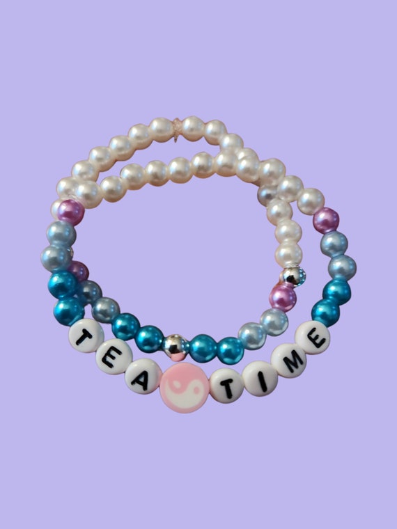 Taylor Swift inspired stacked beaded bracelets that say Tea Time