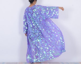 May include: A long, iridescent purple sequined kimono with long sleeves. The kimono is made of a sheer fabric with sequins that shimmer in the light.