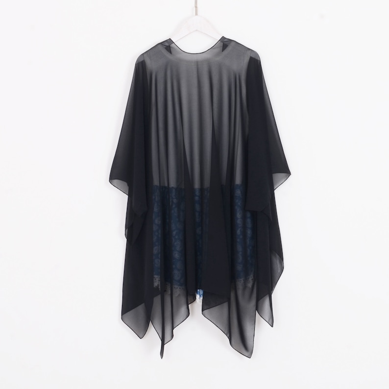 May include: Black sheer chiffon wrap with a triangular hemline. The wrap is lightweight and translucent, and it is perfect for layering over other clothing.