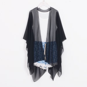 May include: Black sheer kimono with a paisley pattern. The kimono is lightweight and has a flowing silhouette.