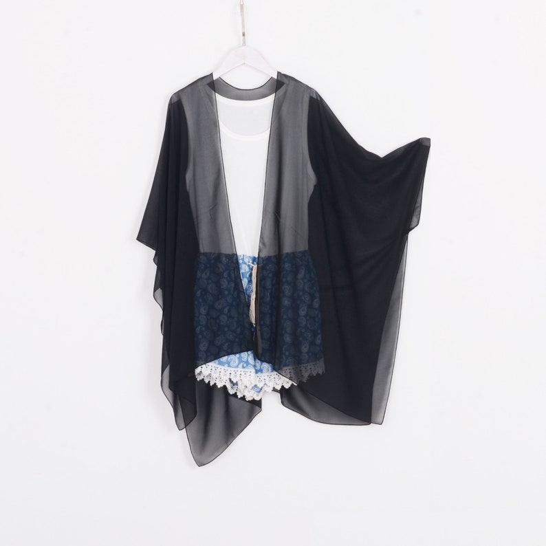 May include: A black sheer kimono with a flowing silhouette. The kimono is lightweight and has a relaxed fit.