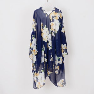 May include: A navy blue sheer floral print kimono with a V-neckline. The kimono has a white and yellow floral pattern.