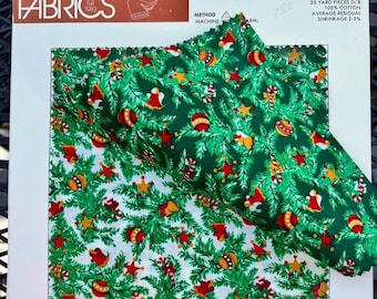 Könnte beinhalten: Weihnachtsdruckstoff mit festlichem Design. Der Stoff zeigt ein Muster aus grünen Tannenzweigen, roten und goldenen Ornamenten, Sternen, Glocken und Zuckerstangen. Der Stoff ist 111,76/114,3 cm breit und besteht aus 100 % Baumwolle. Der Text "CHRISTMAS PRINTS" ist sichtbar.