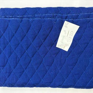 K&ouml;nnte beinhalten: Gefalteter, gesteppter blauer Stoff mit Rautenmuster. Ein kleines wei&szlig;es Etikett ist angebracht, mit dem Text "2 pcs of #4 8.5x20". Der Stoff hat einen leuchtenden Blauton.