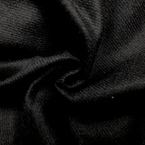 May include: Close-up of black fabric with a textured weave. The material is tightly woven, creating a dense appearance. The fabric is folded and draped, with shadows adding depth and dimension to the image.
