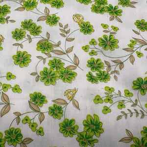 Könnte beinhalten: Weißer Stoff mit einem sich wiederholenden Muster aus grünen Blumen und braunen Stielen. Kleine gelbe und schwarze Insekten sind über das Design verstreut. Das Blumenmuster ist im Vintage-Stil gehalten.