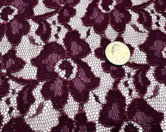 Könnte beinhalten: Nahaufnahme eines bordeauxfarbenen Spitzenstoffs mit floralem Muster. Die Spitze hat einen zarten Netzgrund mit bordeauxfarbenen floralen Designs, die in einem dunkleren Farbton umrandet sind. Eine US-Viertel-Münze ist als Größenreferenz enthalten.