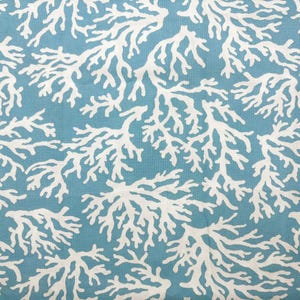 May include: A fabric featuring a repeating pattern of white coral branches set against a solid teal blue background. The design consists of intricate, organic, branching structures spread evenly across the entire surface of the textile material.