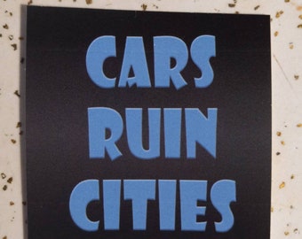 May include: A black and blue sticker with the text "CARS RUIN CITIES" in bold, blue letters.