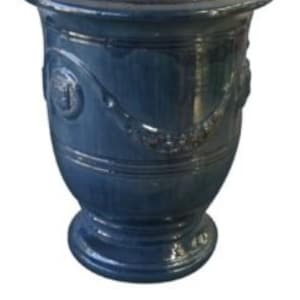 May include: A blue Anduze vase with a wide rim and a decorative design. The vase has a round base and a dark blue glaze. The interior of the vase is a reddish-brown color. The text "VASE ANDUZE BLEU" is at the bottom of the image.