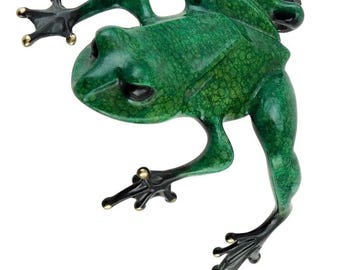 May include: A detailed sculpture of a frog in a vibrant green hue with a textured surface. The frog's feet and toes are black with gold accents. The frog is posed as if it is jumping or climbing.