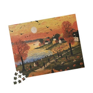 May include: A rectangular jigsaw puzzle depicting a landscape scene with a golden sunset, a body of water, and a small village. The scene features orange-hued trees, numerous small figures walking along a path, and scattered pumpkins.