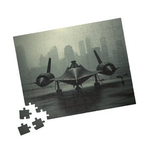 May include: A black SR-71 Blackbird aircraft puzzle with a cityscape background. The puzzle is mostly assembled, with a few pieces separate. The image is in shades of gray and black, creating a dramatic effect.