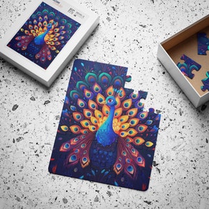 Könnte beinhalten: Ein teilweise zusammengesetztes Puzzle mit einem farbenfrohen Pfau-Design mit blauen, gelben und roten Federn. Das Puzzle liegt auf einer weißen Oberfläche, wobei die Schachtel und einige lose Teile sichtbar sind. Die Schachtel trägt den Text "Custom Made" und "DEVEL-2".