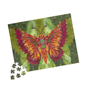 May include: A colourful jigsaw puzzle depicting a butterfly. The butterfly's wings are orange, yellow, and magenta, with detailed patterns. Some puzzle pieces are separate. The background is a blend of green shades.