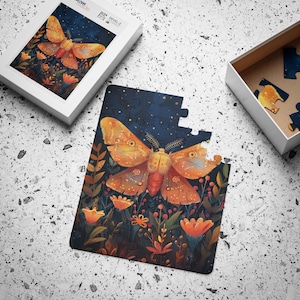 May include: A completed jigsaw puzzle featuring a large, orange and yellow moth with intricate details, surrounded by a dark blue background with small white stars and a variety of colorful flowers.