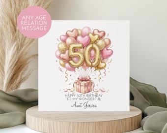 May include: A square greeting card featuring a watercolour illustration of a gift box tied with a ribbon, floating beneath a cluster of pink, gold, and heart-shaped balloons. The number 50 is in gold. Text reads: HAPPY 50TH BIRTHDAY TO MY WONDERFUL Aunt Jessica.
