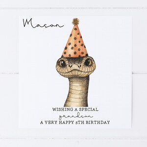 May include: A birthday card featuring a snake wearing a party hat. The card says "Wishing a special grandson a very happy 5th birthday" and is personalised with the name "Mason".