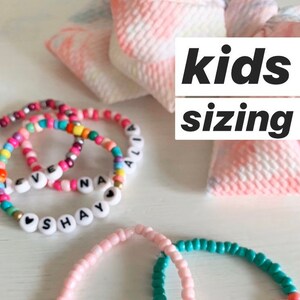 May include: Colorful beaded bracelets with personalized names, including "Shay", "Ali", "Kenley", and "Grace". The bracelets are made with small, colorful beads and white letter beads. The image includes the text "kids sizing".