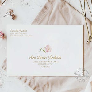 May include: A white envelope with a gold floral design and text that reads "Camille Jenkins, 6564 Bayview Drive, San Francisco, CA 94109" and "Ava Loren Jenkins, 12345 Bluebonnet Lane, Houston, TX 77022".