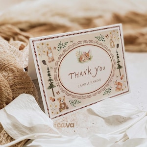 K&ouml;nnte beinhalten: Gefaltete Dankeskarte mit Waldthema. Die Karte zeigt ein zentrales Oval mit den Worten "Thank You" und einem Namen. Der Rand enth&auml;lt Illustrationen eines Rehs, Eichh&ouml;rnchens, Fuchses, B&auml;ren und Kaninchens. Die Karte ist beige mit braunen Akzenten.