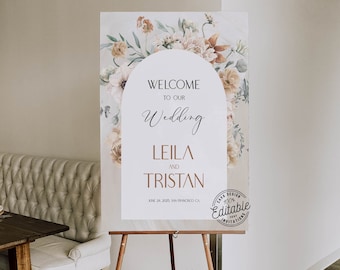 May include: A wedding welcome sign with a floral arch design. The sign is white with black text that reads "Welcome to our Wedding Leila and Tristan June 24, 2025 San Francisco CA". A brown stamp with the text "Cava Design 100% Editable Invitations" is in the bottom right corner.
