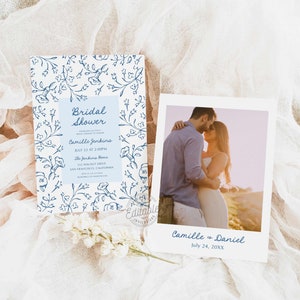 May include: A blue and white floral patterned invitation for a bridal shower. The invitation includes the text "Bridal Shower" and the name "Camille Jenkins". The invitation also includes the date and time of the shower, the location, and the RSVP information. A separate photo card features a couple embracing with the text "Camille & Daniel" and the date "July 24, 20XX".