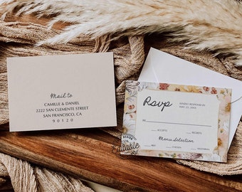 Pode incluir: Um cartão RSVP floral com fundo branco e borda dourada. O texto "RSVP" está escrito em itálico. O cartão inclui uma seção para os convidados indicarem sua presença e uma seleção de menu.