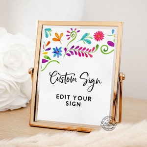 May include: A gold-framed sign with a white background and colourful floral border. The text on the sign reads "Custom Sign Edit Your Sign".