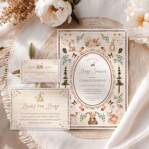May include: Baby shower invitation set with a woodland theme. The invitation features a central oval design with text, surrounded by illustrations of animals, trees, and butterflies. Includes a diaper raffle card and a "Books for Baby" card.