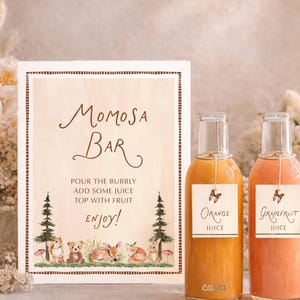 K&ouml;nnte beinhalten: Ein Schild f&uuml;r eine Mimosa-Bar mit dem Text "Momosa Bar" und Anweisungen. Zwei Glasflaschen mit Orangen- und Grapefruitsaft stehen neben dem Schild. Das Schild zeigt auch Illustrationen von Waldtieren.