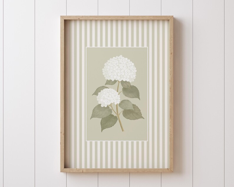 May include: A framed botanical print featuring white hydrangea flowers with green leaves and stems. The artwork is set against a light green background with a striped pattern, encased in a natural wood frame. The print is a decorative piece.