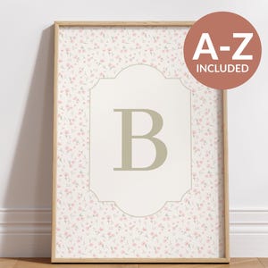 May include: Framed floral print featuring a large letter "B" in a light green hue, set against a cream-colored background with a decorative border. The background is covered in a delicate pink floral pattern. A round sticker with the text "A-Z INCLUDED" is in the upper right corner.