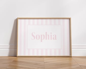 May include: A framed print with a pink and white striped pattern and the name "Sophia" in pink lettering.