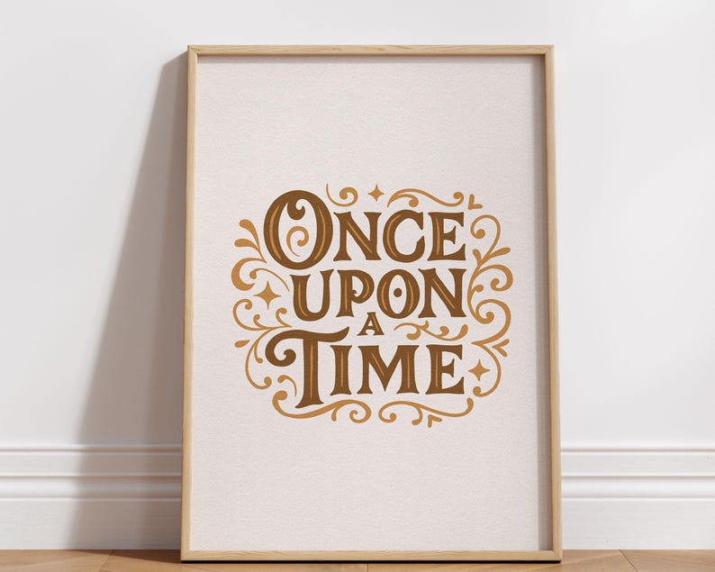 May include: A framed print with the words "ONCE UPON A TIME" in a decorative, vintage-style font. The text is in shades of brown and gold against a cream-colored background. The frame is a light wood color.
