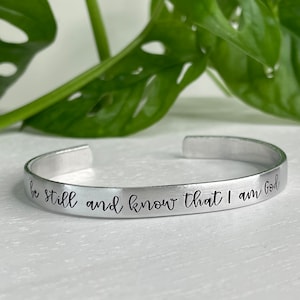 Könnte beinhalten: Silberarmband mit der Inschrift "be still and know that I am God".