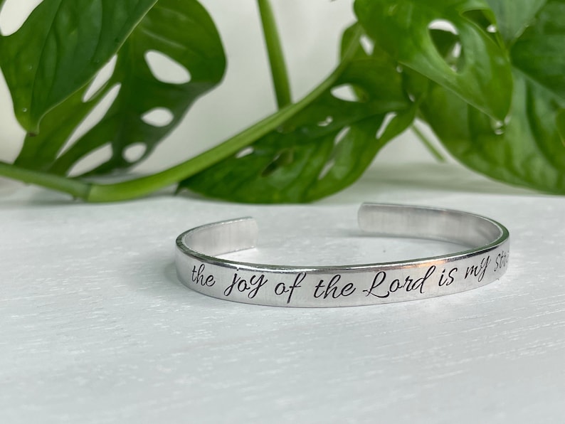 May include: Silver bracelet with the inscription "the joy of the Lord is my strength".