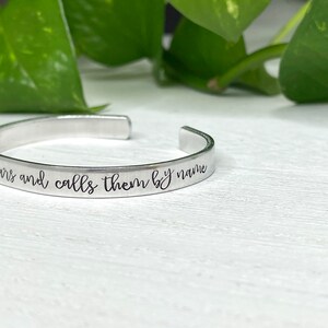 May include: Silver bracelet with the inscription "He knows the stars and calls them by name".