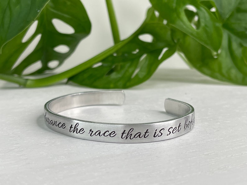 May include: Silver bracelet with the inscription "Endurance the race that is set before you".
