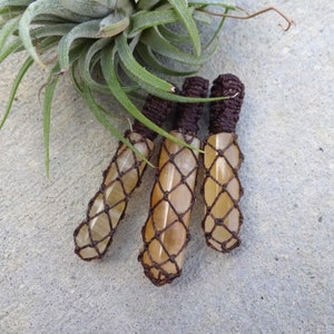 May include: Three yellow crystal pendants wrapped in brown macrame cord.