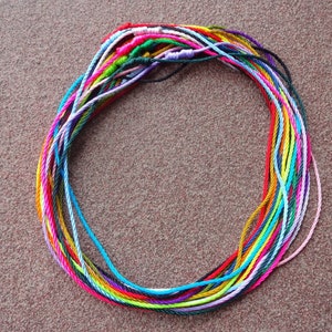 May include: A circle of colorful embroidery floss, arranged in a circular pattern, with a variety of colors including pink, blue, green, yellow, and orange.