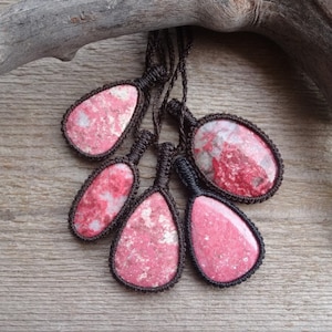 May include: Five red and white gemstone pendants with brown cord necklaces. The pendants are in the shape of teardrops and ovals.