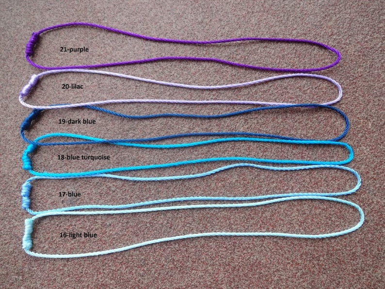 May include: Six different colors of cord, from light blue to purple, are laid out in a row. Each cord has a knot at one end and is labeled with a number and color. The colors are light blue, blue, blue turquoise, dark blue, lilac, and purple.